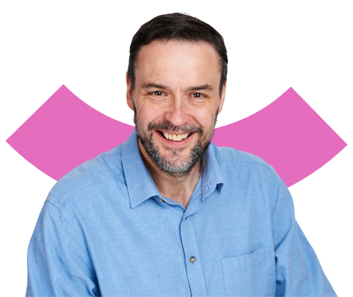 A portrait of a smiling, middle aged white man with short hair and beard